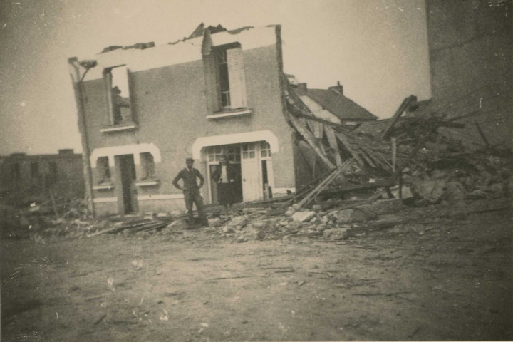 Un homme et une femme devant une maison en ruines.