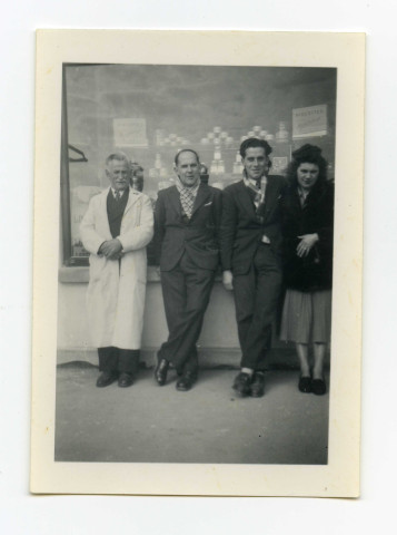 Portrait de famille devant le magasin, trois hommes et une femme.