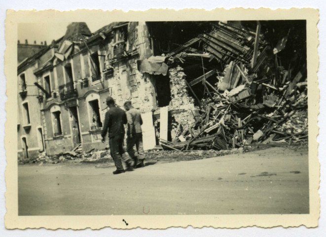 [ Deux hommes en uniforme vus de dos dans la rue Villès Martin en ruine ]. - Saint-Nazaire, [vers 1943]