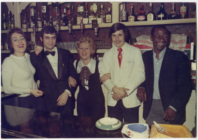 Maria, au centre et Souleymane Diallo, à droite, posent avec leur 3 employés au bar de leur brasserie à Nantes
