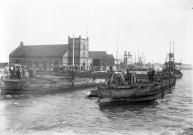 [Saint-Nazaire.- Le naufrage du remorqueur Croisic : épave du remorqueur dans le port encadrée par des bateaux, vue sur la foule sur les quais]. - mai-juin 1938