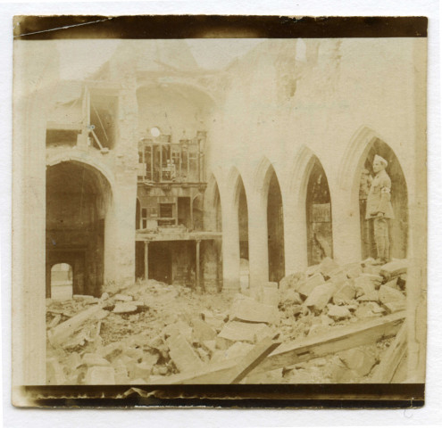 [Marcel Hauton debout sur un amas de pierres à l'intérieur de la cathédrale de Roye détruite]. - Roye, 3 septembre 1917