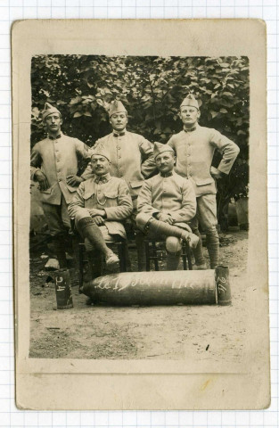 Groupe de soldats, dont Emile Guéry, posant devant un obus