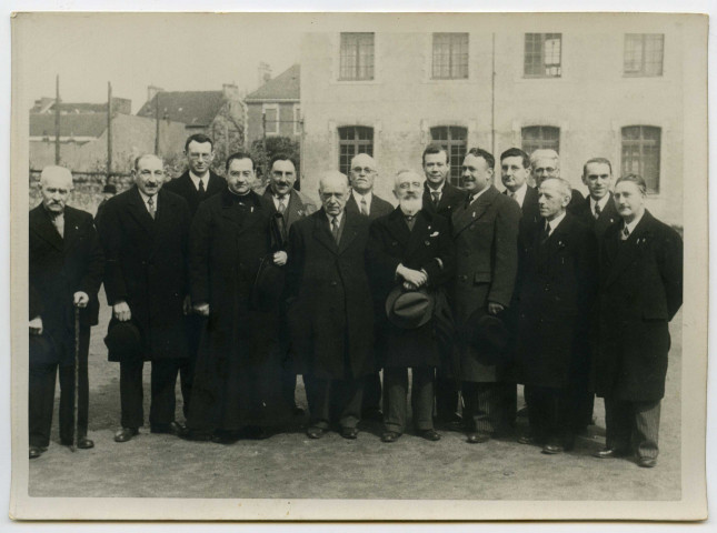 Groupe d'hommes posant devant un bâtiment