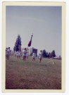Chantal Le Mercier (SNOS gymnastique) portant le drapeau, à 17 ans, entourée d'autres gymnastes féminines, lors d'une rencontre à Mâcon (recto-verso).