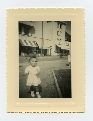 Jeune enfant de la famille Toussaint devant l'Epicerie du Trianon du boulevard Gambetta et Square de la mutualité : photographies