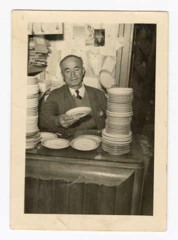 M. Pierre Zollet père à l'entrée du magasin place Marceau avec sa petite fille Madame Zollet-Duquenoy et M. Pierre Zollet père dans son magasin place Marceau : 2 photographies.