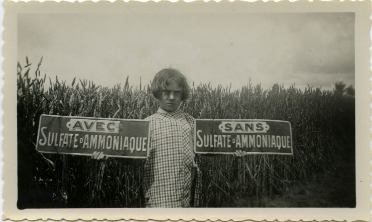 Photographie d' Une élève du cours agricole à l’Immaculée porte deux panneaux "avec et sans sulfate-ammoniaque", des pesticides, en 1933 - Fonds Luce-Pasquier, 27J / Archives de Saint-Nazaire