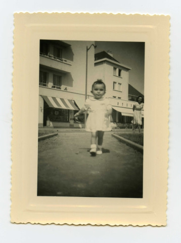 Jeune enfant de la famille Toussaint devant l'Epicerie du Trianon du boulevard Gambetta et Square de la mutualité : photographies