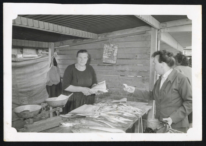 Commerce familial provisoire : poissonnerie. Marie Nédélec vend du poisson à une cliente.