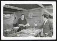 Commerce familial provisoire : poissonnerie. Marie Nédélec vend du poisson à une cliente.