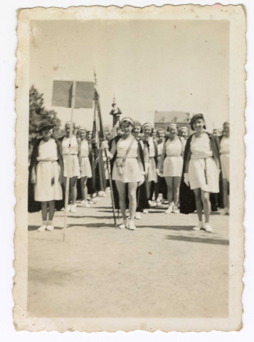 Marcelle Le Mercier de l'Espérance, à l'âge d'environ 15 ans, portant l'étendard, entourée de gymnastes féminines.
